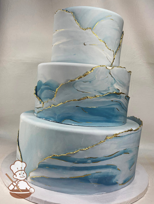 3 tier blue marble fondant in layers painted with gold shimmer accents.
