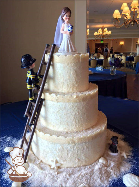 3-tier cake with patted sugar sand and top of each tier with added castel trim.