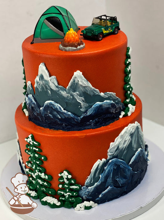 2-tier orange cake with hand painted tall mountain peaks and large trees with snow caps.