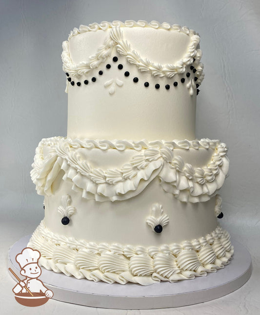 2-tier cake with smooth white icing and victorian-style piping techniques and black accents.