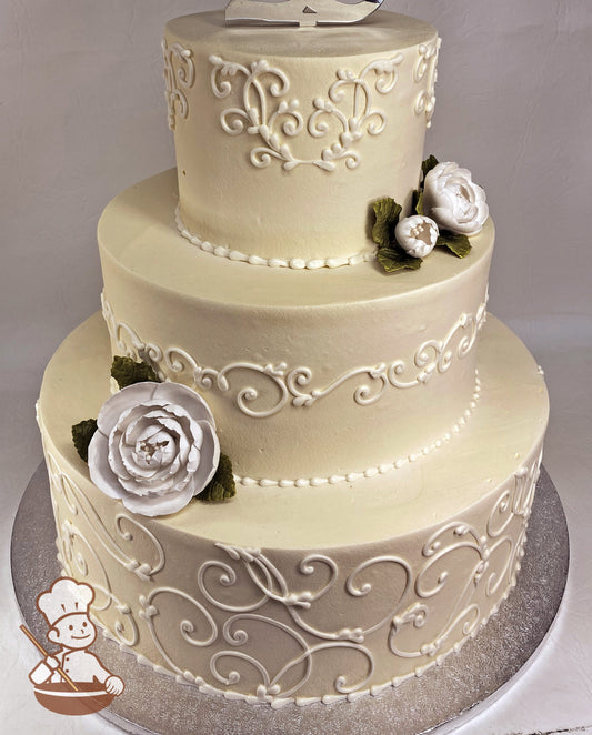 3-tier ivory-colored cake with hand-piped scrolls and white sugar roses with green sugar leaves.
