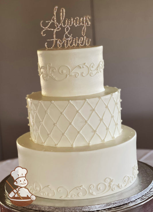 3-tier cake with smooth white icing and hand-piped scrolls on the bottom and top tier and a hand-piped quilt pattern with white pearls in middle.