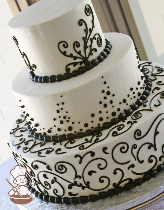 3-tier cake with smooth white icing and black scrolls on the bottom and top tier and black buttercream dots in the middle tier.