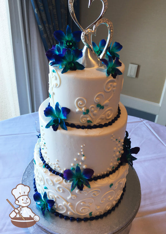 3-tier cake with smooth white icing and white buttercream scrolls on the bottom and top tier and white buttercream dots in the middle tier.