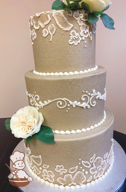 3 tier round wedding cake with warm silver tone buttercream icing and white buttercream brushed florals and elegant piping design.