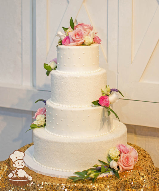 4 tier round wedding cake with alternating sugar crystal cover tiers and white pearl bead piping design.  Cake is finished with fresh flowers.
