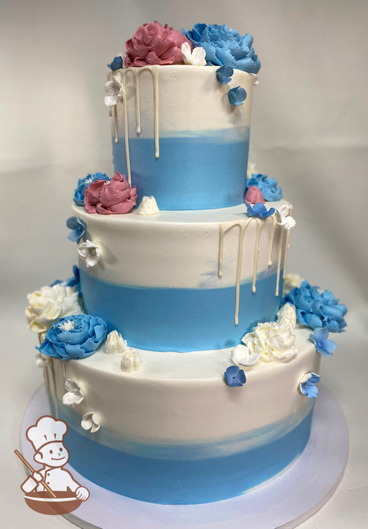 3 tier wedding cake with 2 tone buttercream in blue & white & decorated with White chocolate drip and buttercream flowers with sugar hydrangeas.