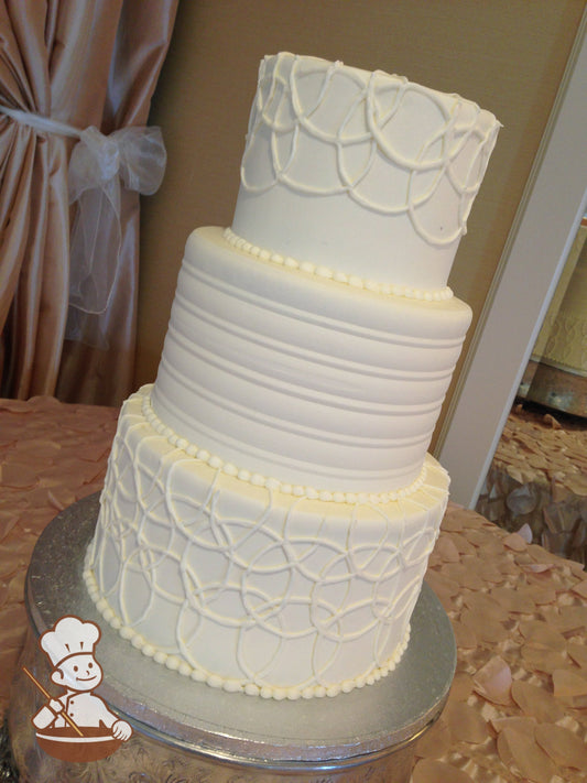 3 tier wedding cake with round pattern in middle tier and overlapping circle pipings on top & bottom tiers.