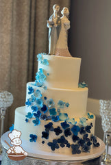 3 tier wedding cake with sugar hydrangeas in blue hues cascading down the cake.