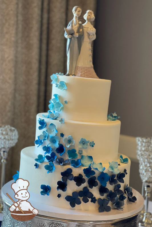3 tier wedding cake with sugar hydrangeas in blue hues cascading down the cake.