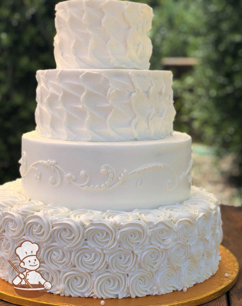 4-tier cake with white icing and decorated with rosettes on the bottom tier, scrolls on the second tier and texture on the third and top tier.