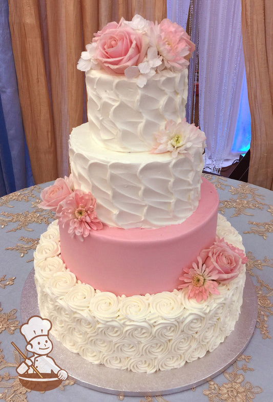 4-tier cake with white rosettes on the bottom tier, pink smooth icing on the second tier, and white textured icing on the third and top tier.