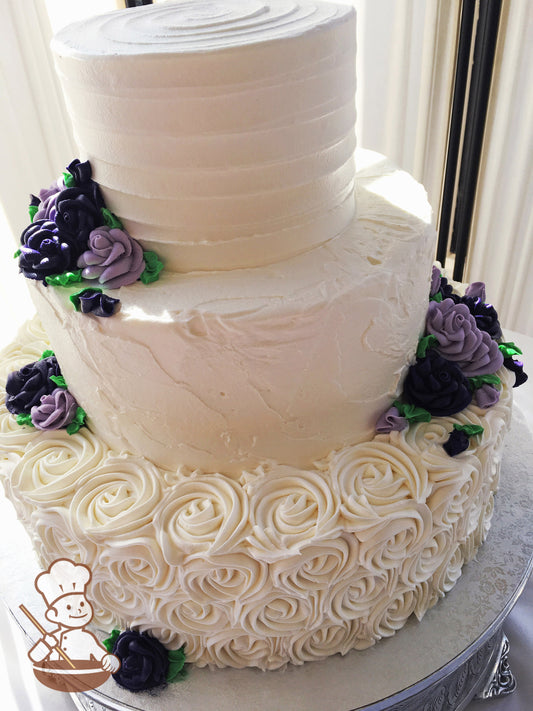 3-tier cake with white icing, decorated with rosettes on the bottom tier, a stucco-like texture in the middle tier and horizontal texture on top.