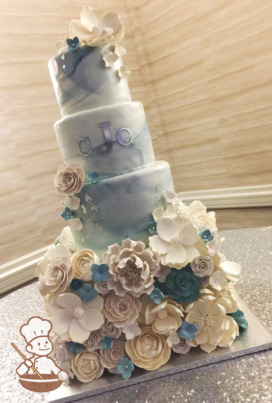 4 tier fondant wedding cake with square bottom covered with sugar flowers and top rounds covered with marble fondant and monograms.