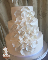3 tier fondant wedding cake with fondant rose petals cascading down the cake and finished with pearlescent shimmer spray.