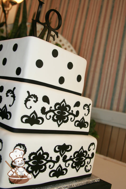 3 tier square fondant cake with black art deco and polkadot designs on cake walls.
