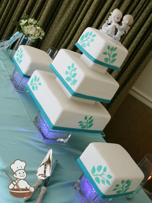 Multi tiered square fondant cake with decorative gaps and fondant wrap on base and fondant leaves decor.