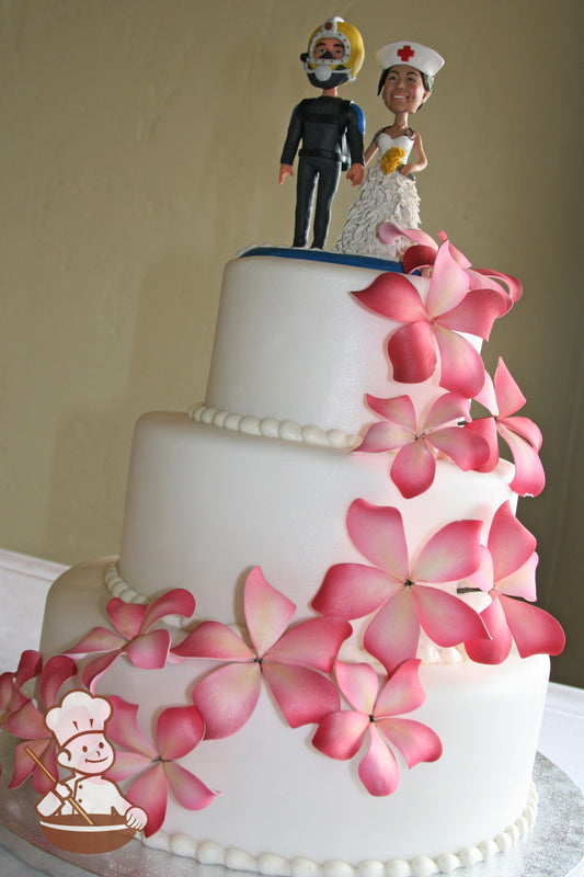 3 tier fondant wedding cake with hand colored (pinks to burgundies) sugar plumerias.