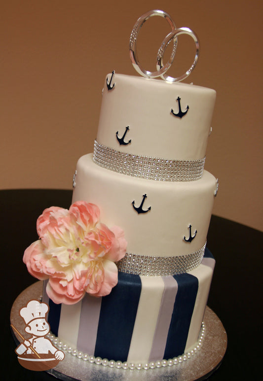 3 tier fondant wedding cake with vertical white, navy blue and gray fondant stripes and decorated with navy blue anchors on top 2 tiers.