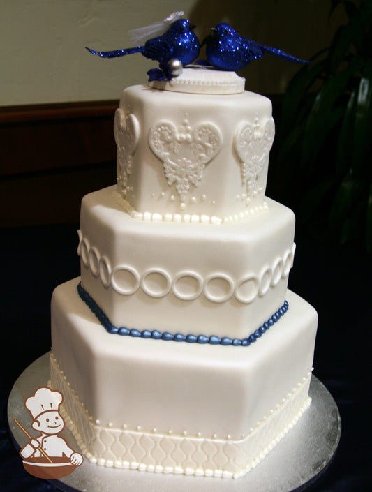 3 tier hexagon shaped fondant wedding cake with vintage fondant decor on the walls.