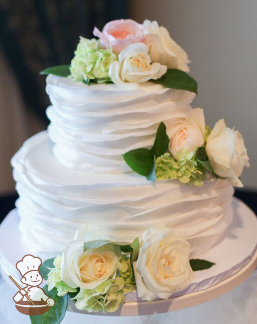 2 tier wedding cake with flower petal wrap and fresh flower decoration.