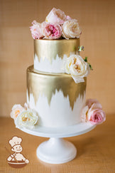2 tier fondant wedding cake with top down gold painted designs.