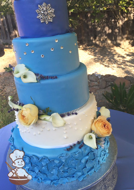 5 tier fondant wedding cake with blue and white fondant tiers decorated with blue fondant flowers, rhinestones, crystal broach and fresh flowers.