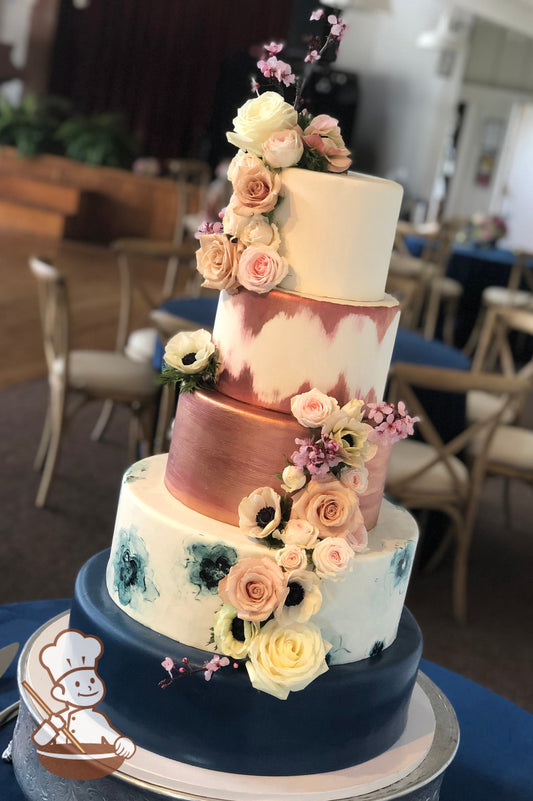 Round fondant wedding cake with navy blue base, painted flower 2nd tier, rose gold painted top tiers and finished with cascading fresh flowers.