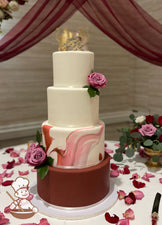Round fondant wedding cake with burgundy bottom tier and burgundy marbled 2nd tier painted with gold accents. Smooth white top 2 tiers & flowers.