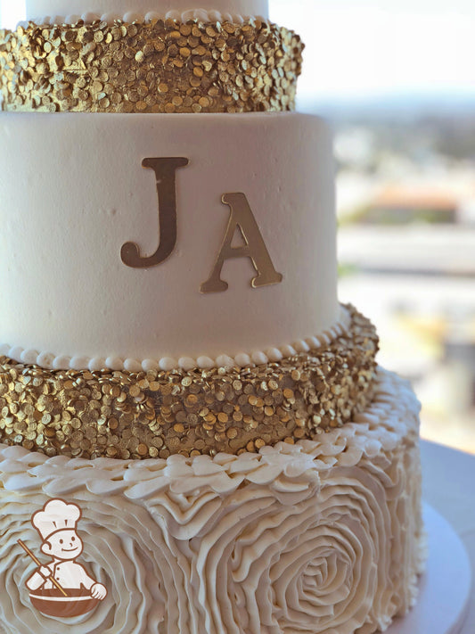 Cake decorated with white buttercream ruffles, gold sequins and a gold monogram.