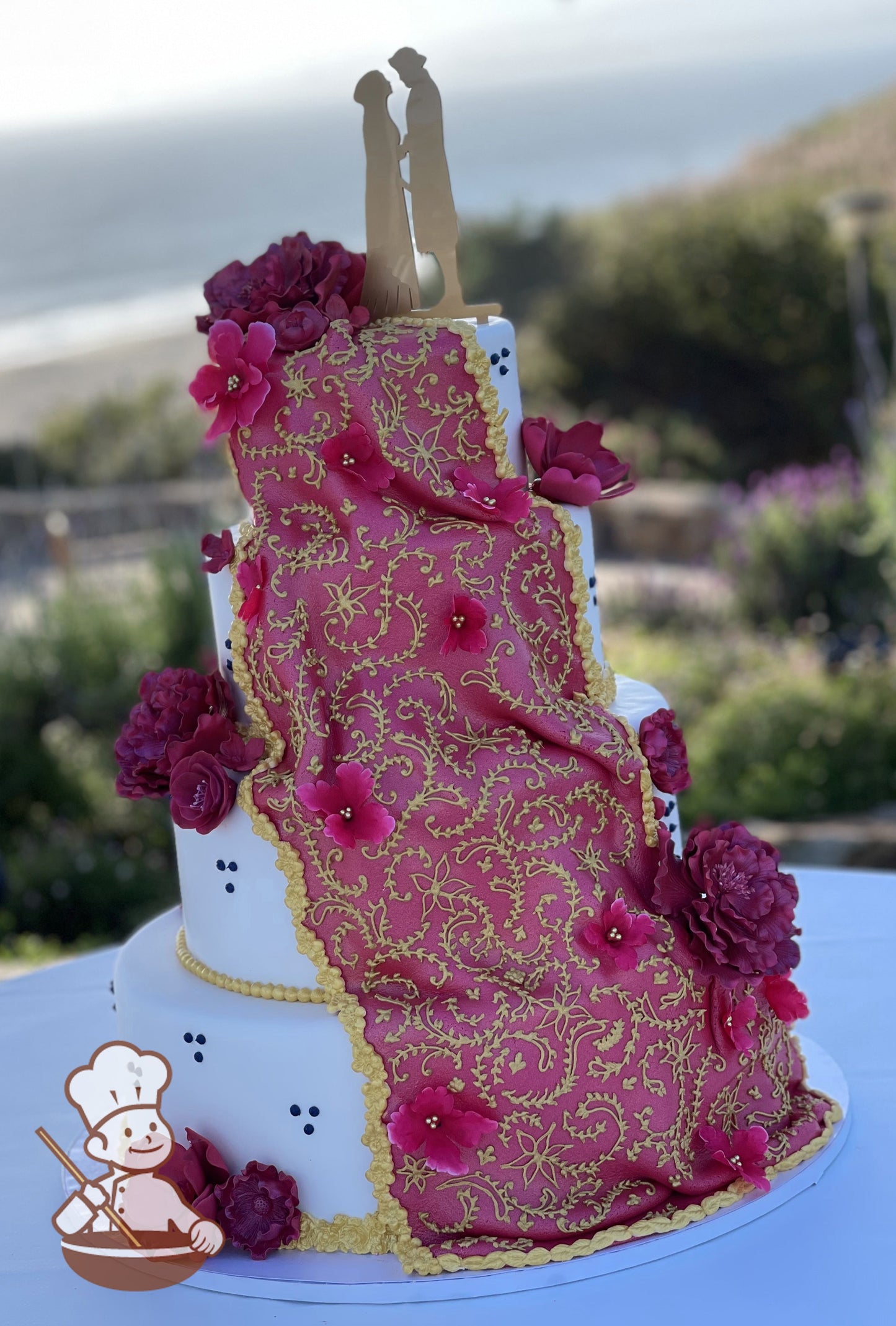 4-tier cake with tri-dots and burgundy flowers. Large fuscia fondant is draped down the cake and hand piped in gold patterns and lace.