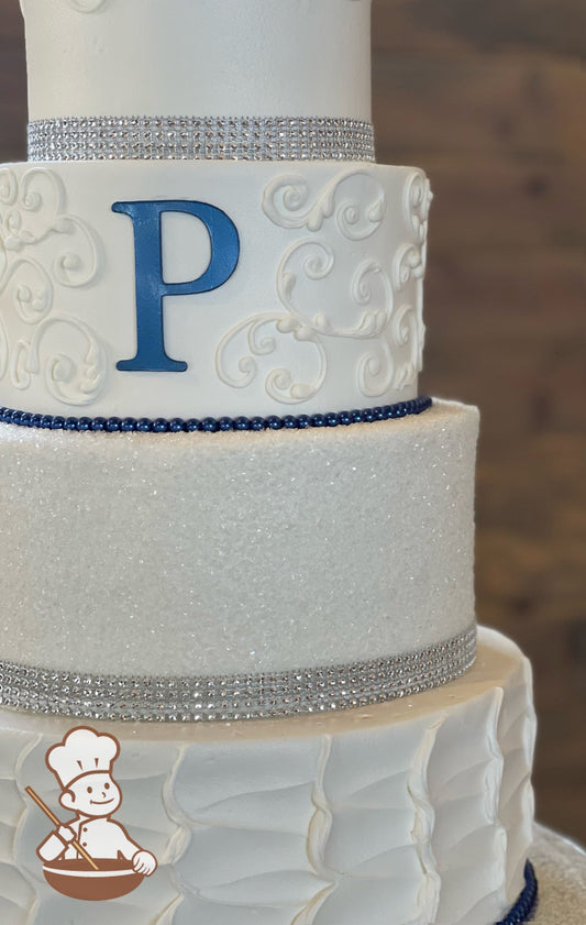 4-tier cake with scrolls, sugar crystal, rustic textures, and decorated with silver rhinestone bands, blue pearl strands and monogram "P".