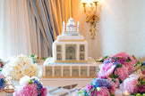 Large Taj Mahal Indian Themed Cake surrounded by fresh flowers on table spread.