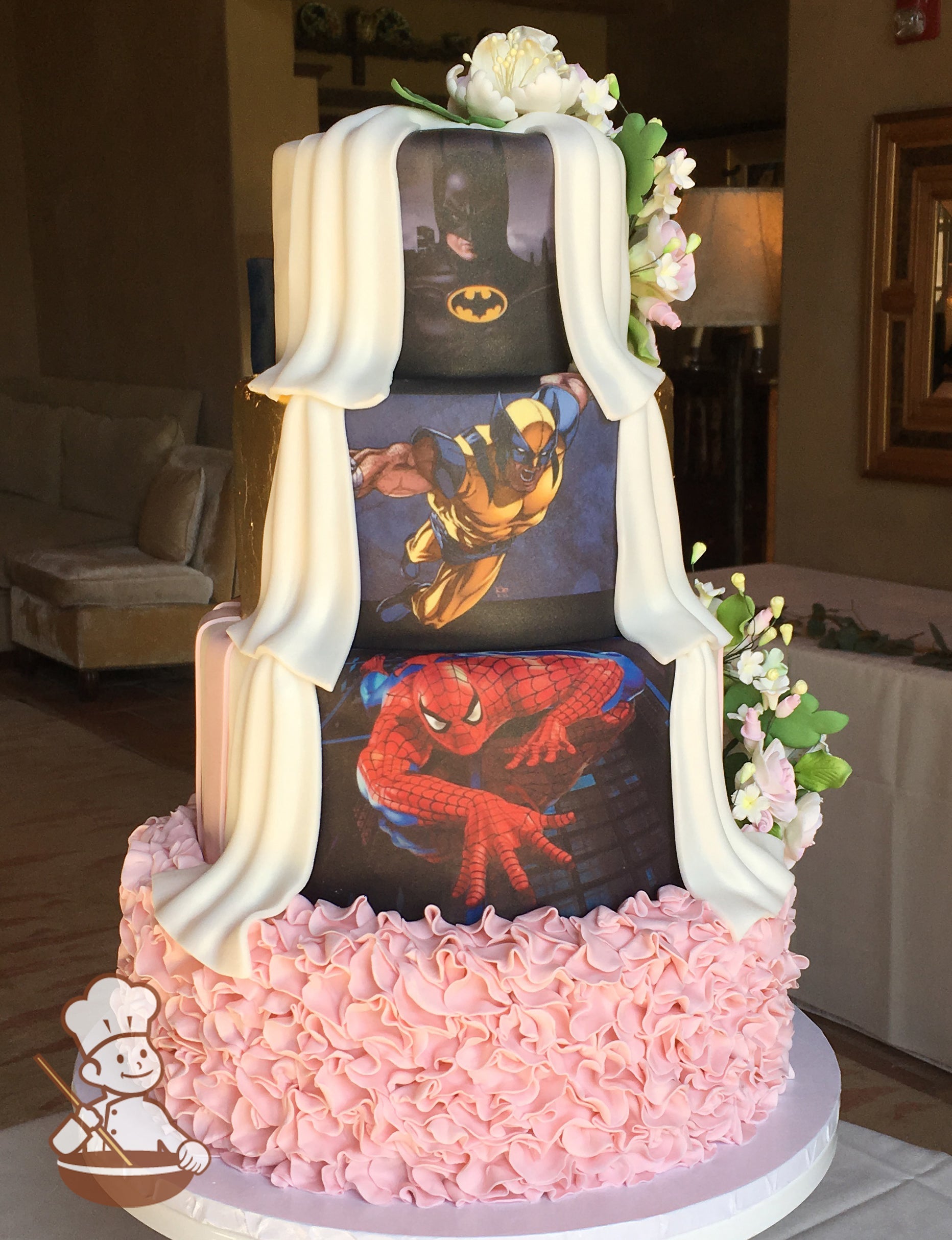 His side cake decoated with images of Batman, Wolverine, and Spiderman; separated from Her side with white fondant drapes. 