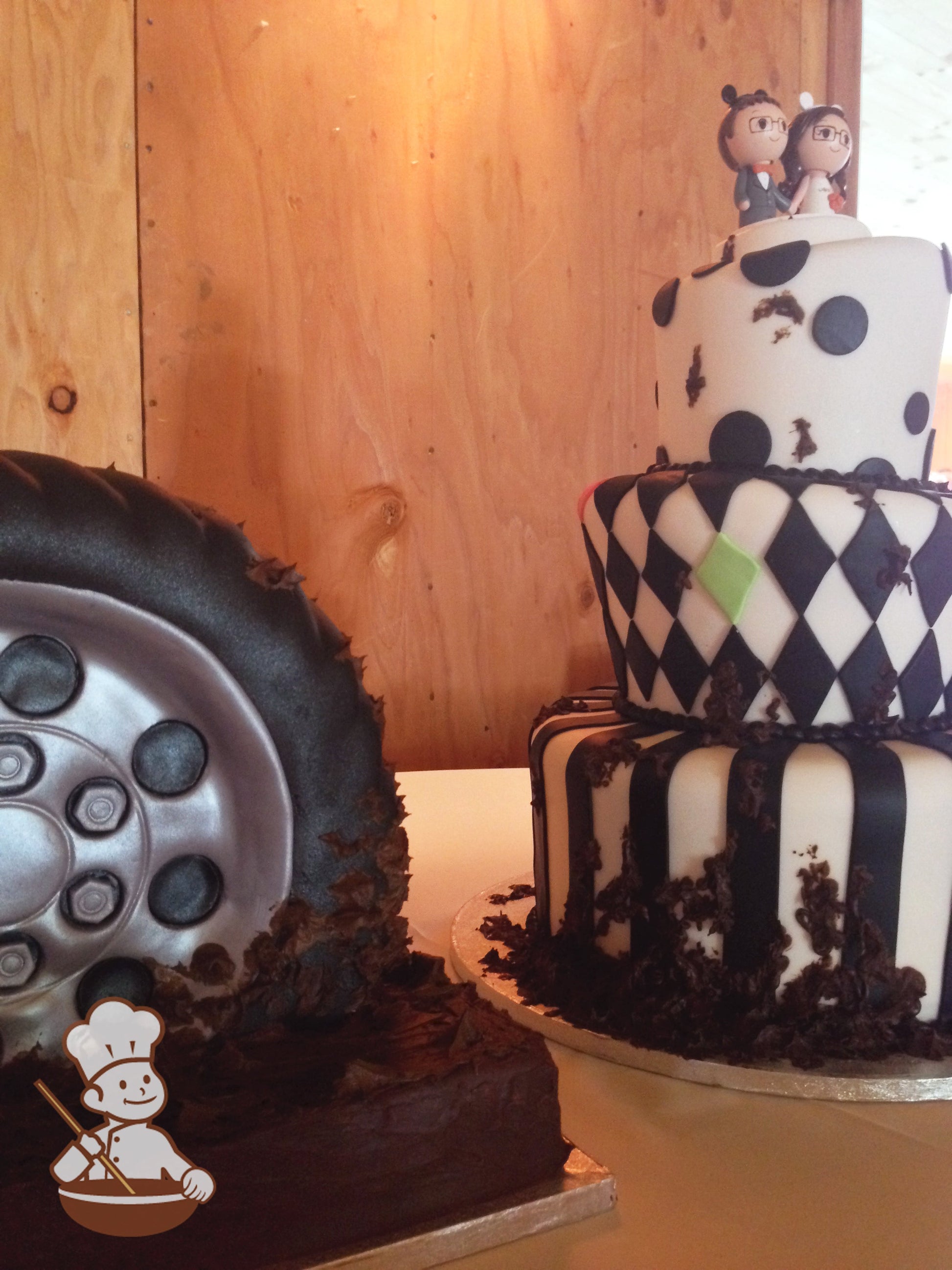 A tire shaped groom's cake is next to the main cake.