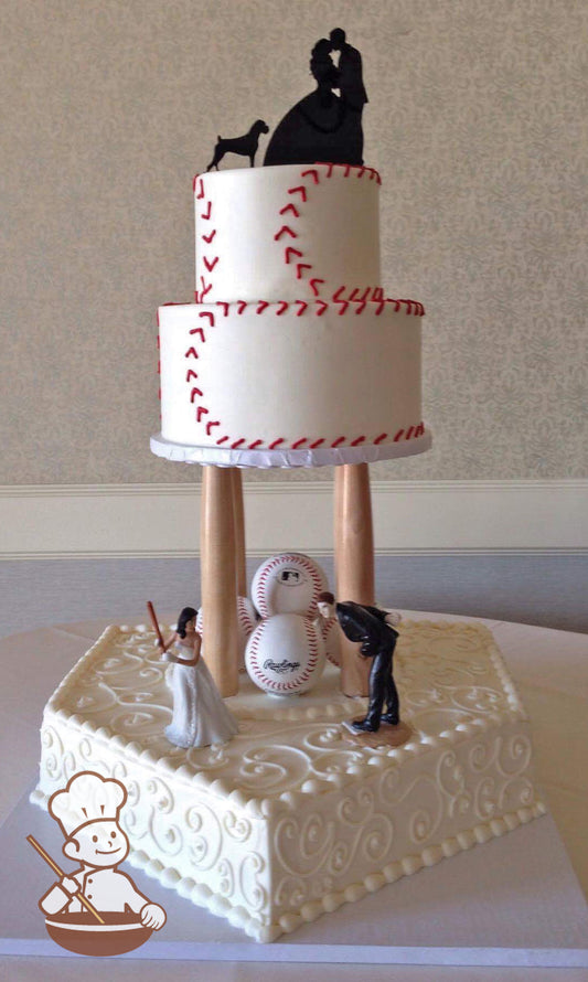 Baseball base shaped cake with scrolls and four baseball bats holding up a 2-tier cake with baseball stitching patterns.