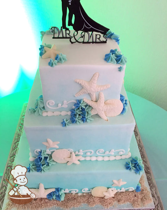 3-tier cake decorated with a light-blue ombre coloring, seashells, buttercream scrolls and multi-color buttercream star drops.