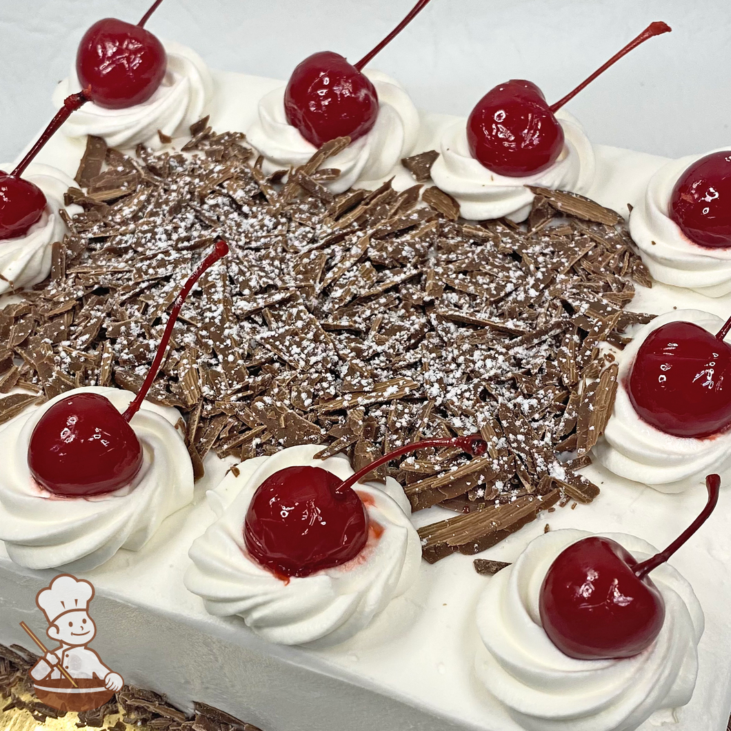 Sheet cake with whipped cream dollops and chocolate shavings with maraschino cherries.