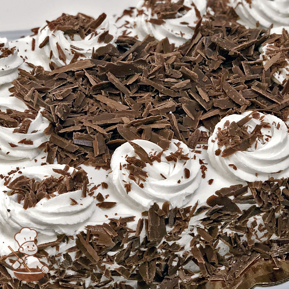 Sheet cake with whipped cream and chocolate shavings.