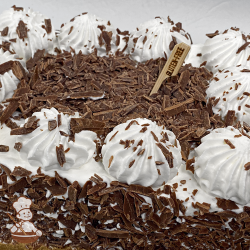 Sheet cake with whipped cream and chocolate shavings.